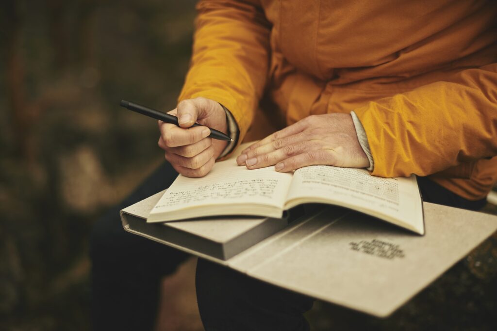 adult writing by hand in journal